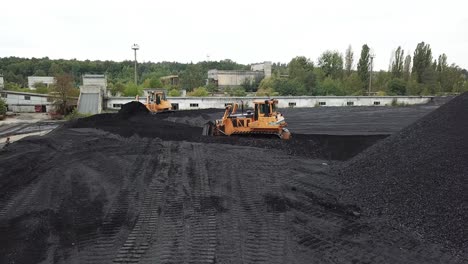 bulldozer at coal warehouse. tractor using for loading coal into trucks for further transport