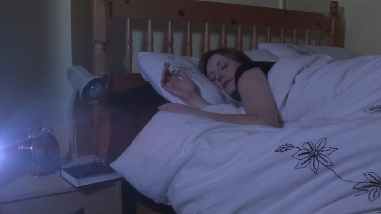 animación de luces brillantes sobre una mujer caucásica solitaria durmiendo