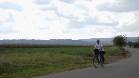 a man rides his bike on a rural road