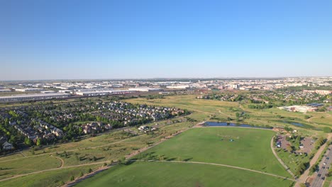 Aerial-Drone-flyover-of-park-in-the-Stapleton-neighborhood-of-Denver,-Colorado-during-golden-hour-on-a-clear-summer-evening