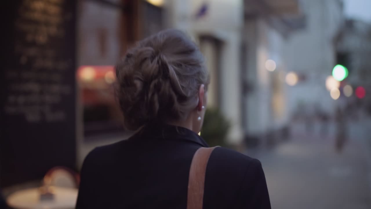 Business woman leaves for work from dark corridor to street in morning