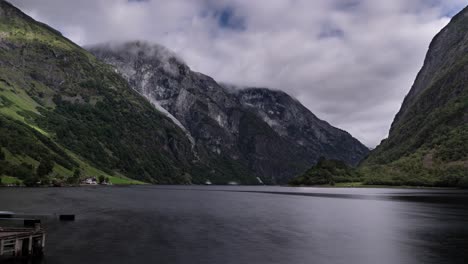 timelapse of a naeroyfjord in norway, stormy clouds forming over the mountains, boats and ferries cruise fast as time passes