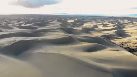 a fly-over drone shot of the vast sand dunes of the little sahara in utah