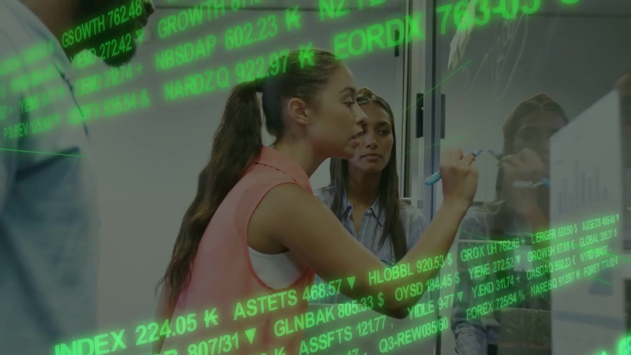 Businesswomen Collaborating on Financial Data in Modern Office