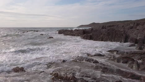 waves breaking at a rocky cove in devon during sunset