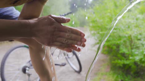 Mann-Trinkt-Natürliches-Quellwasser-Im-Wald.