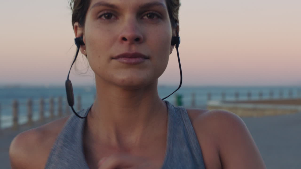 mujer, cara y corriendo con música en la playa