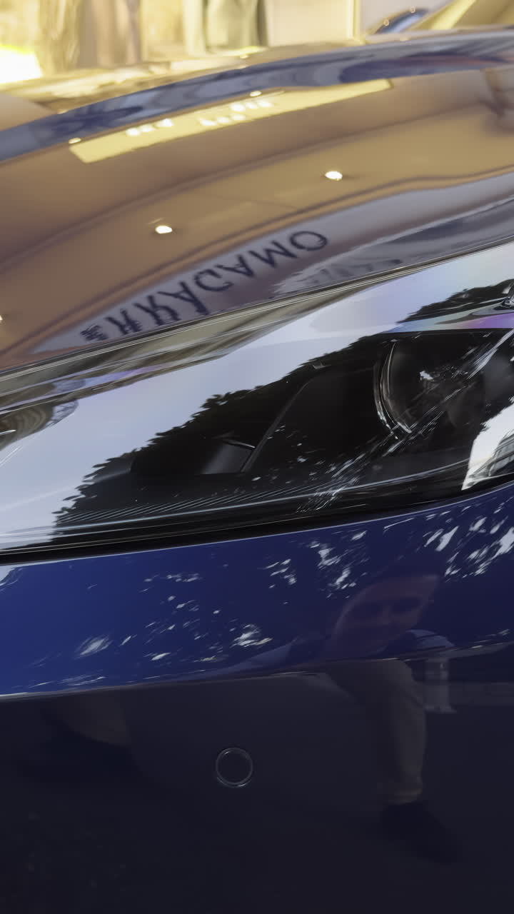 Close-up of a blue car's headlight and front bumper
