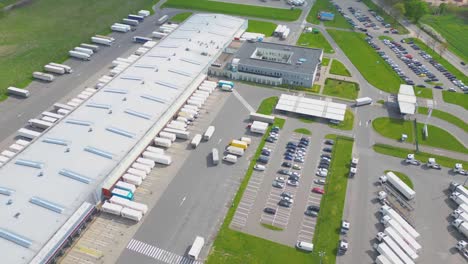 parque logístico de lapso de tiempo con almacén, centro de carga y muchos semirremolques con remolques de carga de pie en las rampas para cargar y descargar mercancías