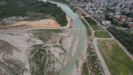 video of nature and cityscape while flying over stream bed with drone.