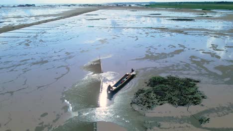 vista aérea de un pescador asiático revisando las trampas para peces y las redes en busca de alimentos durante los bajos niveles de agua en el lago tonle sap en asia.