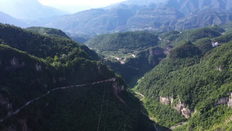 Impresionantes-Imágenes-Aéreas-Sobre-La-Carretera-Con-El-Tráfico-Que-Pasa-A-Través-De-Un-Bosque-Impresionante,-Una-Gran-Altitud-Y-Una-Carretera-Sinuosa,-Capturadas-En-La-Provincia-De-Hebei,-China