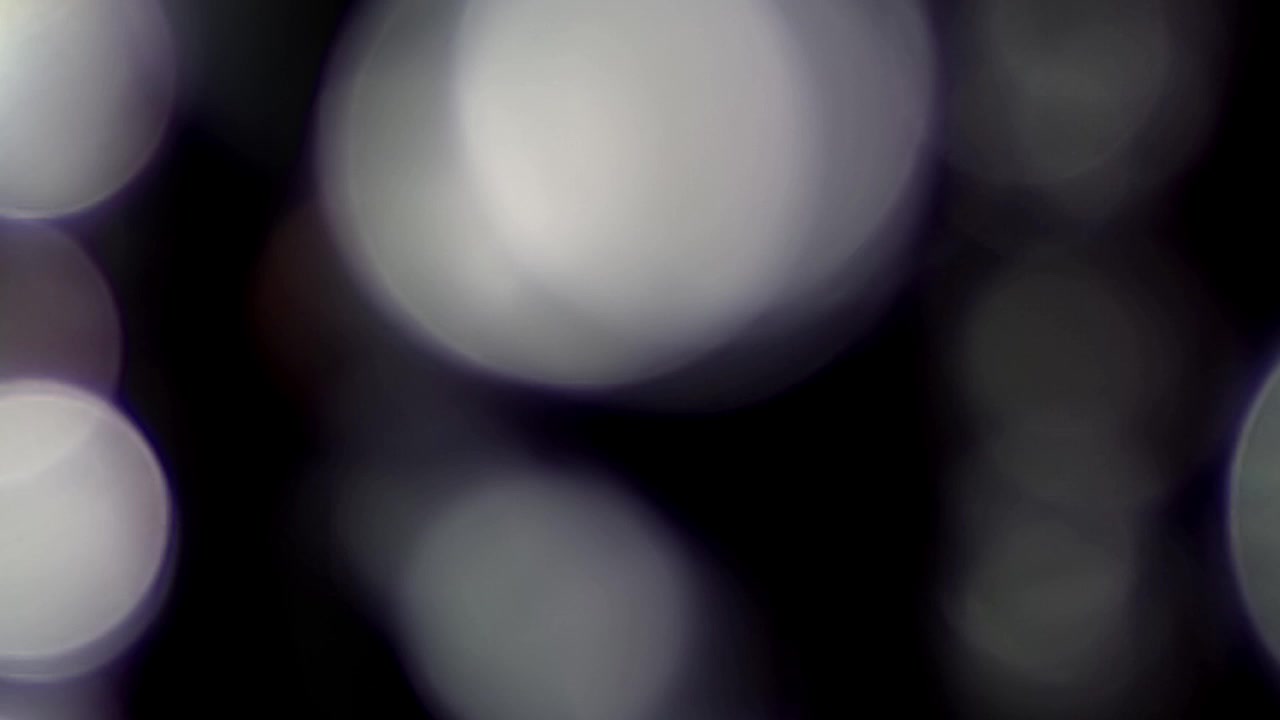Abstrakte glitrende bokeh-lys som overlay på mørk baggrund