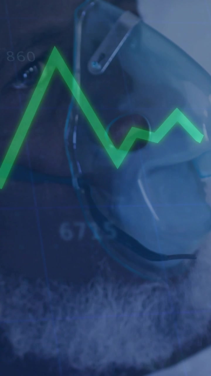 Video verticale: Paziente uomo che respira con maschera O2, monitor medico che legge i parametri vitali e anima i grafici.