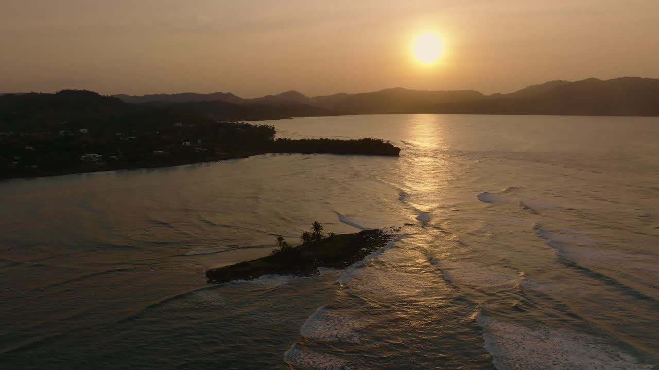 일몰 시간 동안 작은 섬이 있는 캐리비안 바다 위로 영화 같은 드론 비행