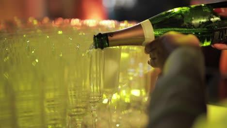 crop bartender pouring champagne in glasses