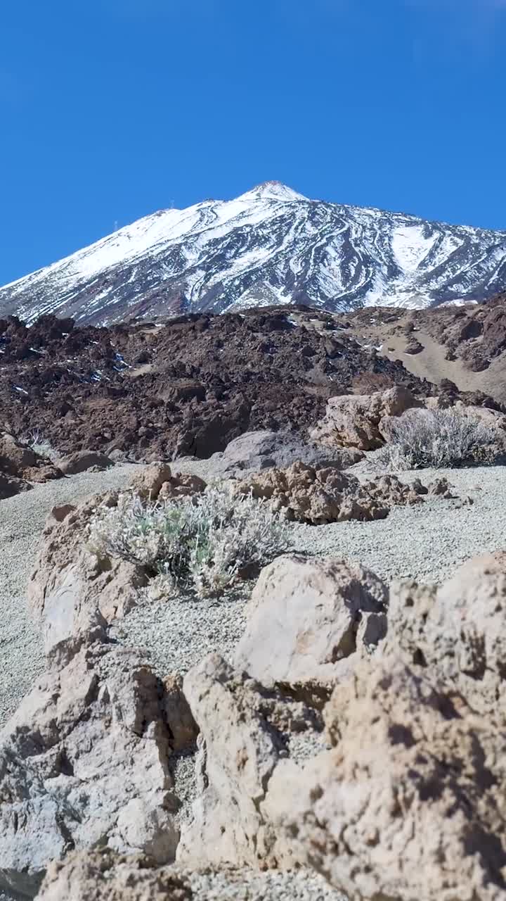 Maestoso vulcano innevato in un arido paesaggio roccioso