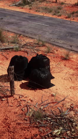 trash bags on a dirt road