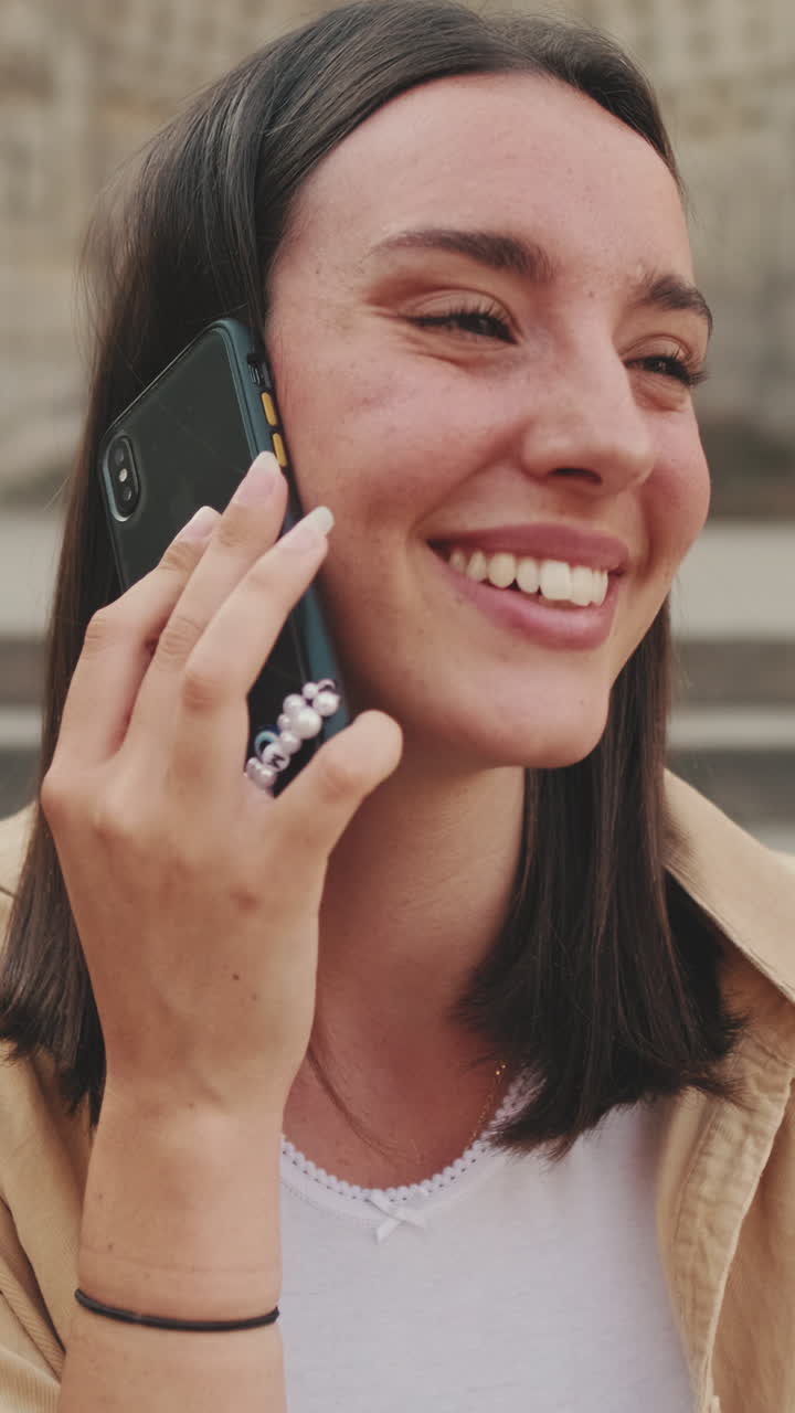 Giovane donna felice che ride mentre parla al cellulare