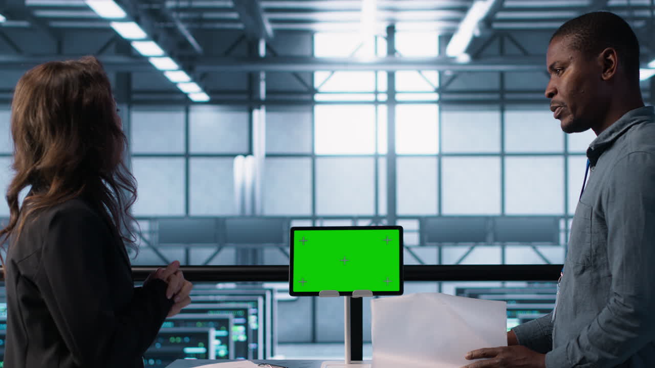 엔지니어가 모 장치와 함께 서버 을 감독하고 문서를 읽습니다.