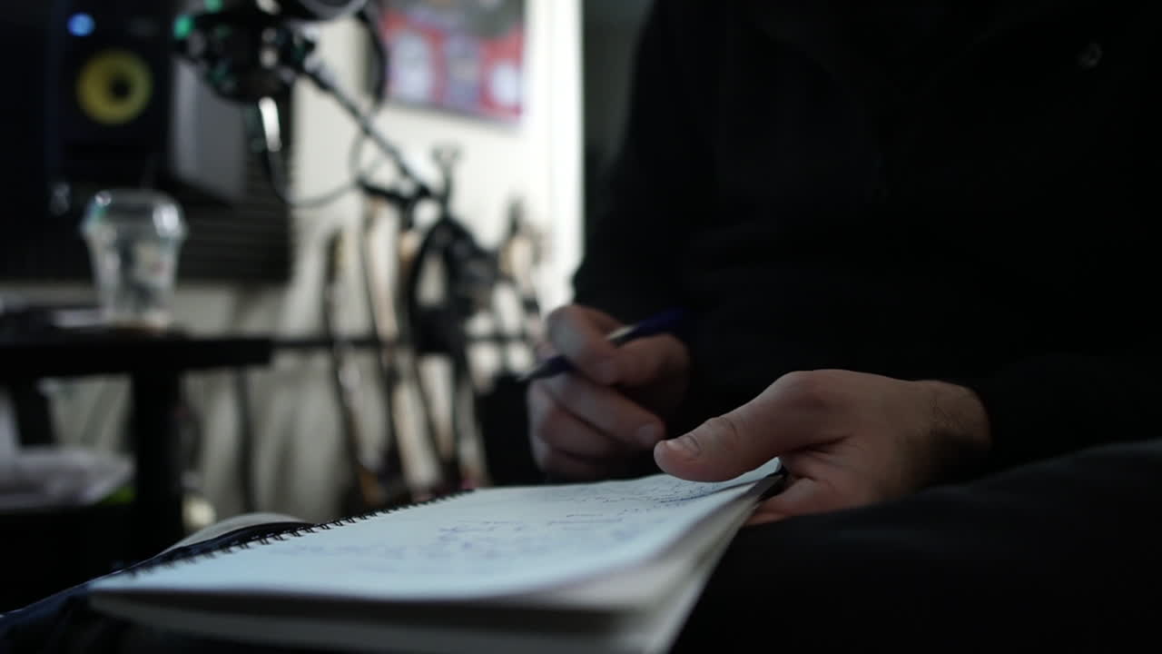 hombre tomando notas en el estudio de música, tiro a mano