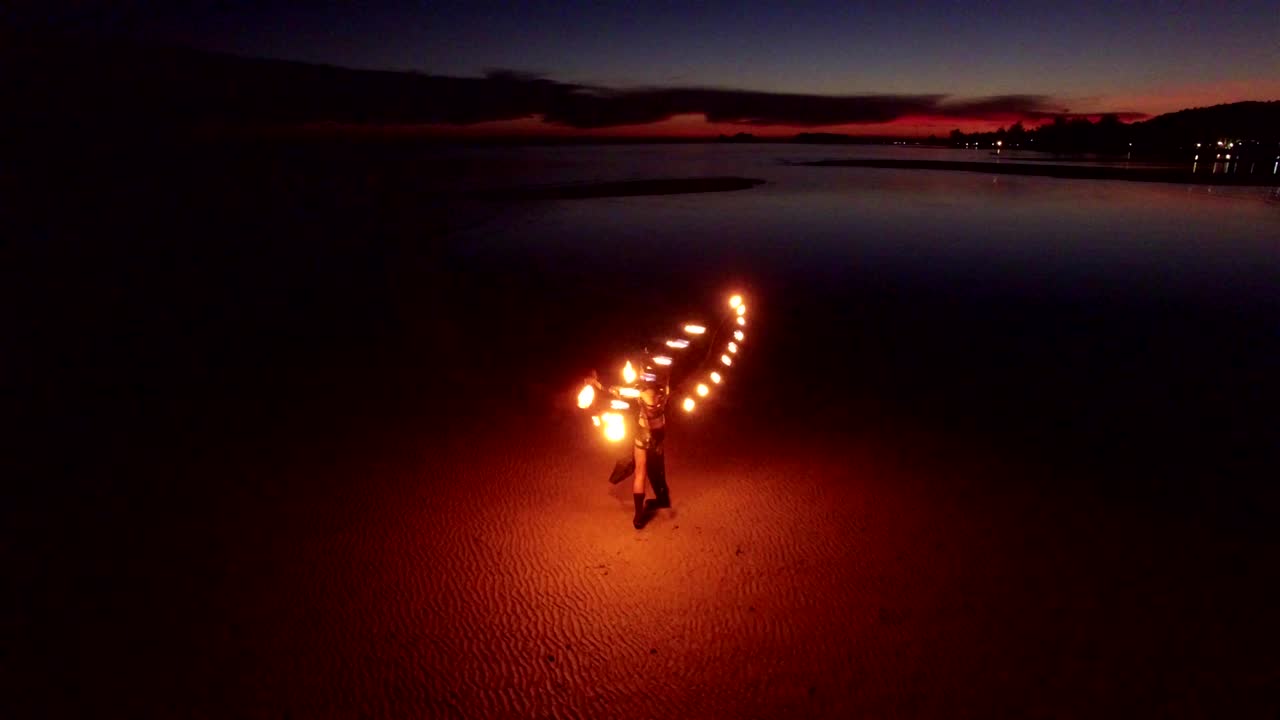 해가 지는 모래 해변에서 춤추는 불 쇼