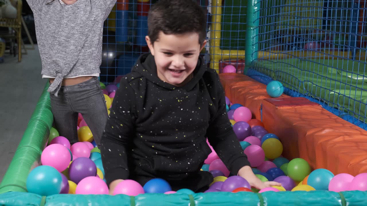 Happy children playing together and having fun at kindergarten with colorful balls. 5-6 years old
