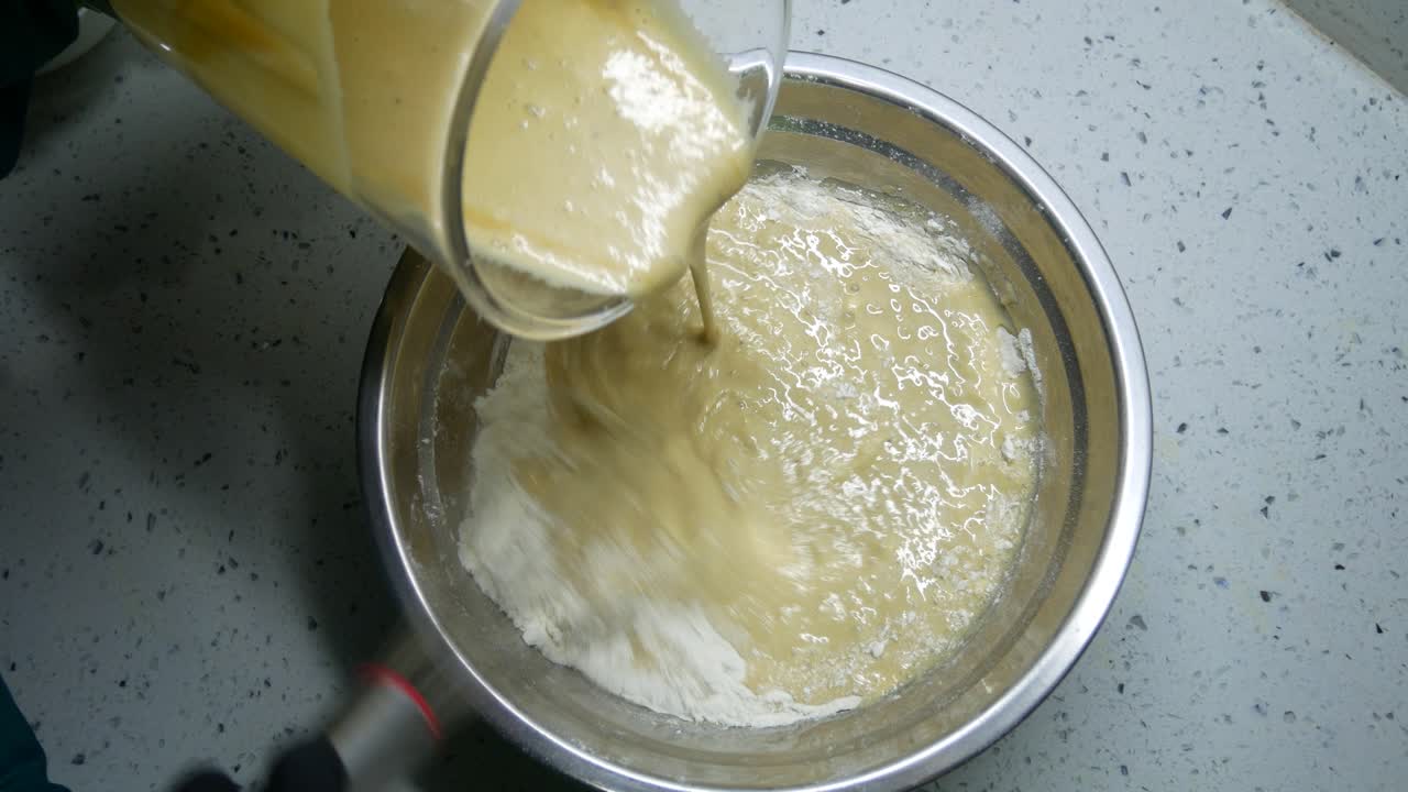 Mix the flour and other ingredients until well blended manually. It is the early stage of the baking bread and cakes process. This will take some time to get a good mix.