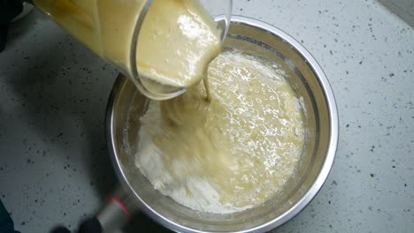mix the flour and other ingredients until well blended manually. it is the early stage of the baking bread and cakes process. this will take some time to get a good mix.