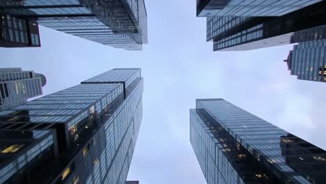 a captivating perspective of urban skyscrapers: gazing upward amidst the gleaming facades and architectural wonders of modern high-rise buildings