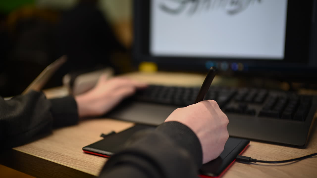 Persona che usa una tavoletta grafica collegata a un computer per lavoro di design digitale.