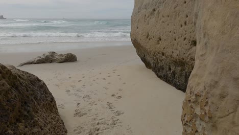 slow walk to beautiful secluded beach past graffiti on huge sandstone cliff face - tunnel beach track, dunedin