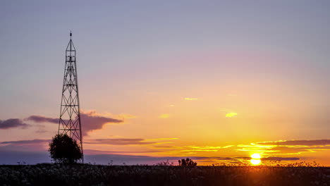 Zeitraffer-Eines-Lebhaften-Sonnenaufgangshimmels-Mit-Wolken-Hinter-Einem-Funkturm-–-Kopierraum