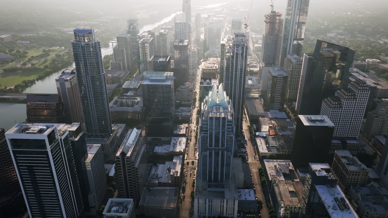 Aerial view of a sprawling city skyline with a river on a hazy morning