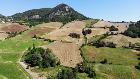 A-drone-flies-down-on-Emilia-Romagna-hills-with-lots-of-fields-and-green