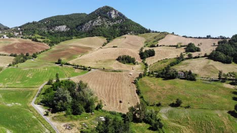 a drone flies down on emilia romagna hills with lots of fields and green