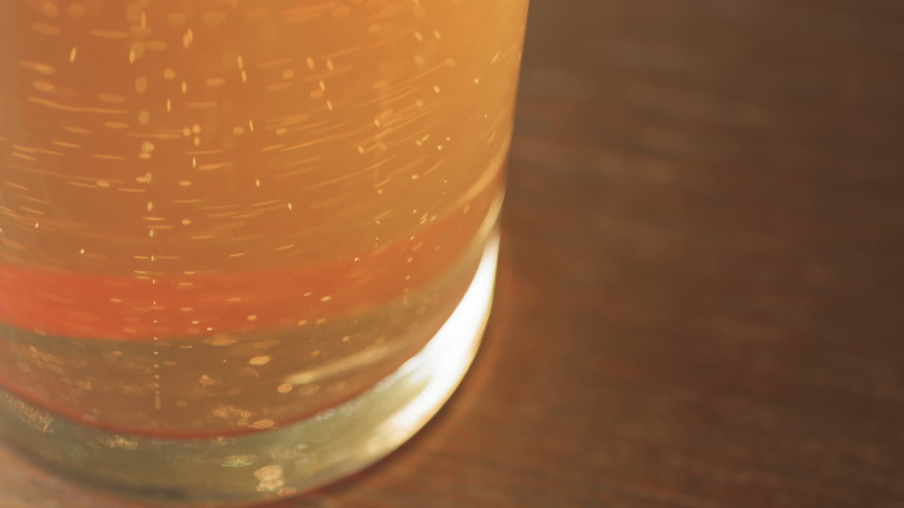 Bolle di birra che salgono dal fondo di un bicchiere da pinta, con spazio per il testo.