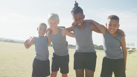 Video-of-happy-diverse-boys-walking-on-grass-and-holding-arms