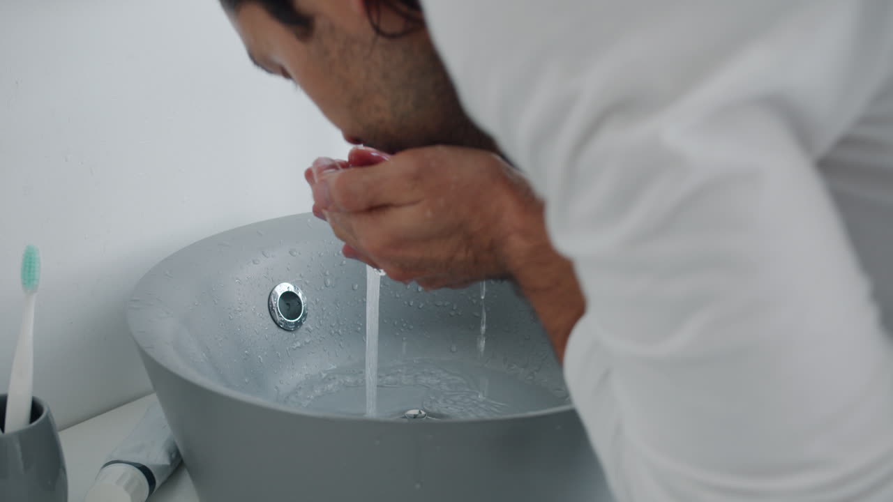 Man washing hands in a bathroom sink