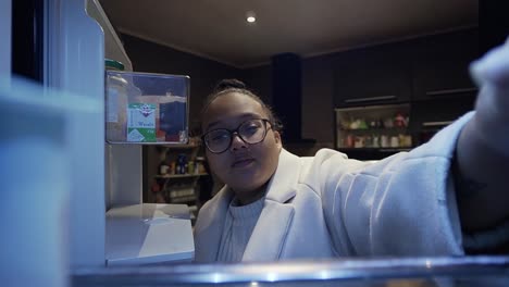 Woman-opening-the-fridge-and-taking-out-a-yoghurt