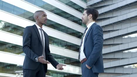 smiling male colleagues greeting each other