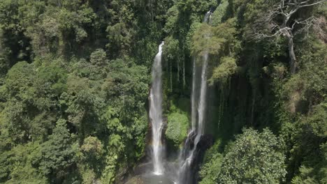 aerial: subtle rainbow at base of bali jungle sekumpul waterfall