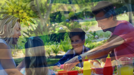 animation of flag of uruguay over caucasian family eating in garden