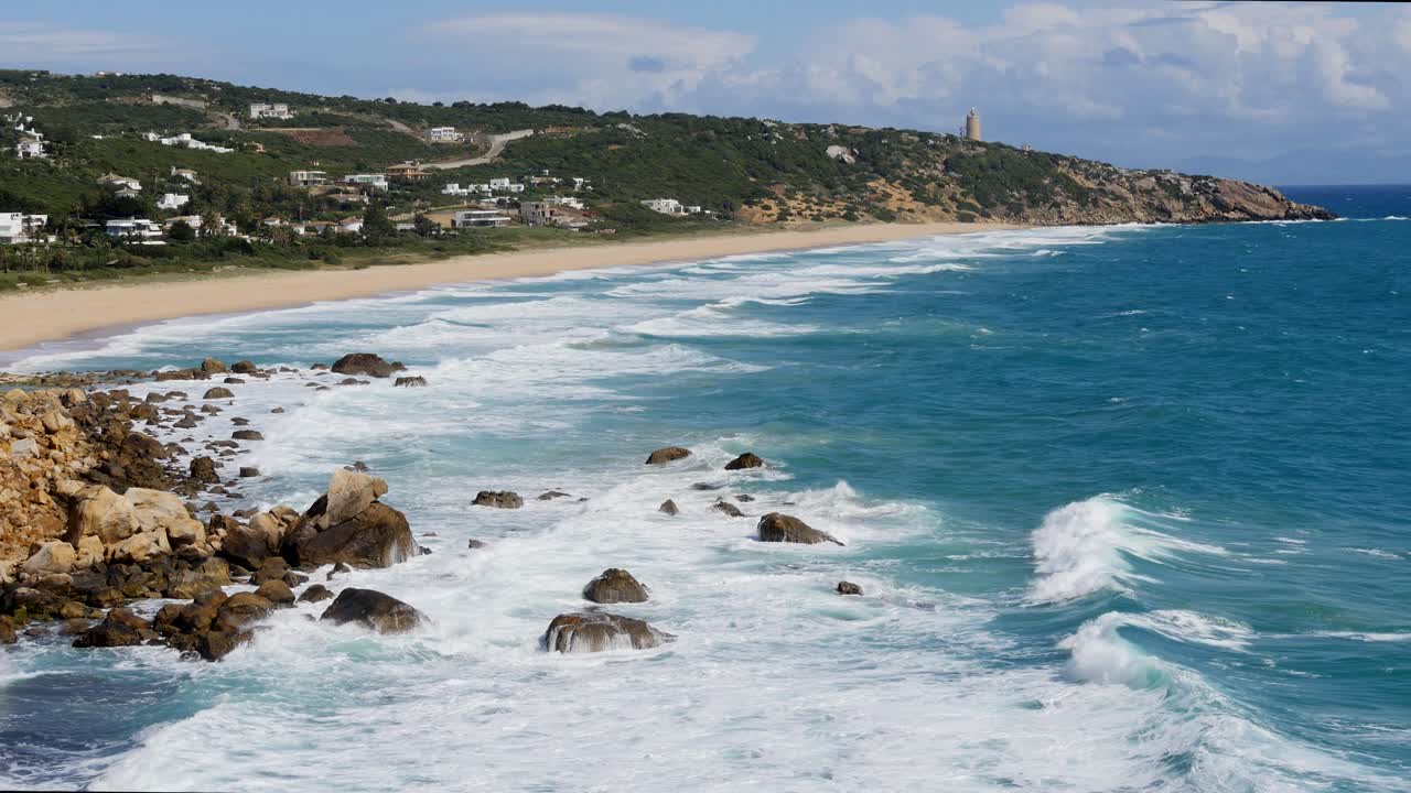 phare de camarinal, 등대 카메라 = 멜리아 아틀란테라에서 등대를 향해 찍은 바위 위로 파도가 밀려오는 해변의 정적인 장면