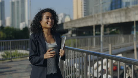 business woman walking in the city with laptop and coffee