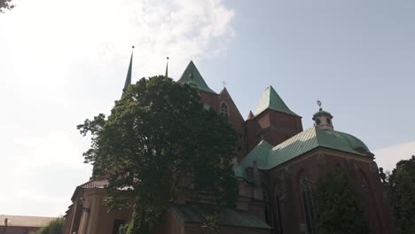 the st. john the baptist archcathedral, a historic architectural gem, stands beautifully adorned with lush greenery in wrocław, poland. tilt up shot