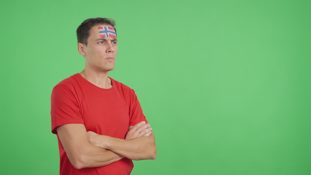 Man with norwegian flag painted looking away with serious expression