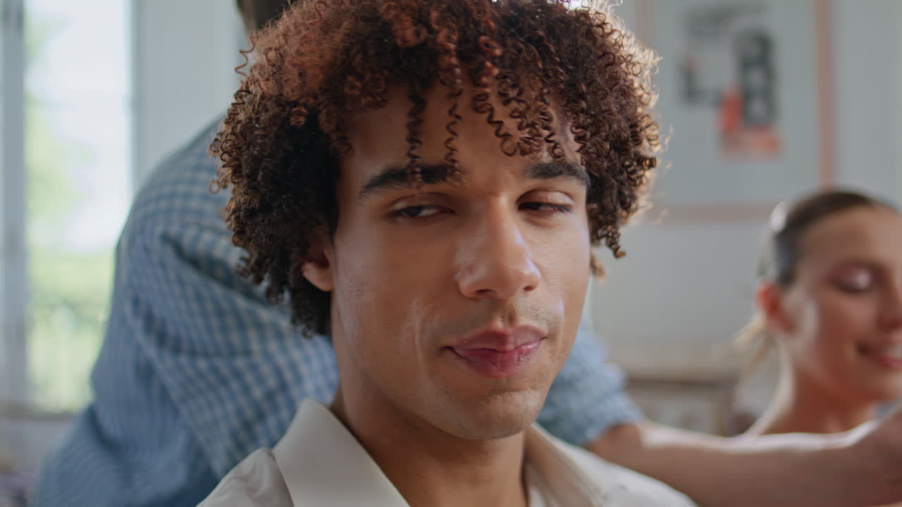 Closeup curly teenager watching movie with friends at home party. Happy teens