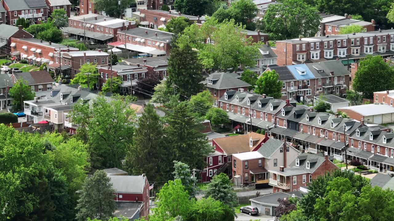 Historic townhouses and row of homes in brick style on sunny day in summer. Small American town of Pennsylvania. Aerial wide shot.