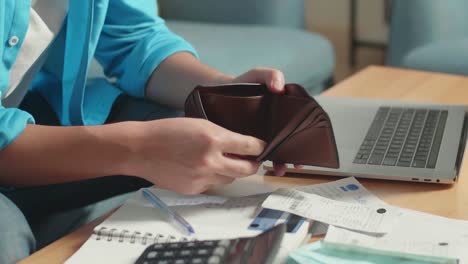 cerca de la mano del hombre sosteniendo el billete luego abriendo la billetera para comprobar el dinero